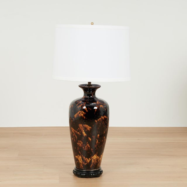 Chic pair of mid century table lamps crafted in ceramic in classic form with a faux tortoise finish under a heavy glaze....