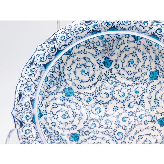 A stunning Iznik plate in a piecrust shape. This beautiful example of early 20th-century Iznik pottery features the iconic...