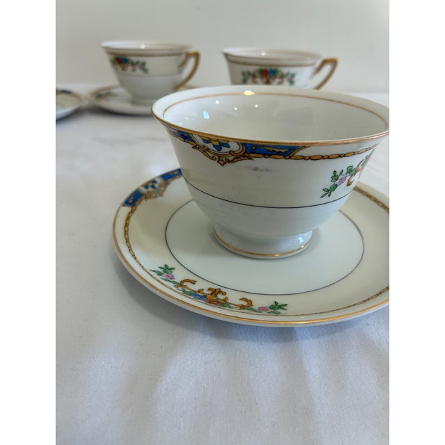 Set of 5 hand-painted porcelain cups and saucers by Meito China, made in Japan and marked “Warren” on the base. Each...