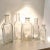 This early 20th century grouping includes five clear glass apothecary bottles with cork tops, each showing some cloudiness...