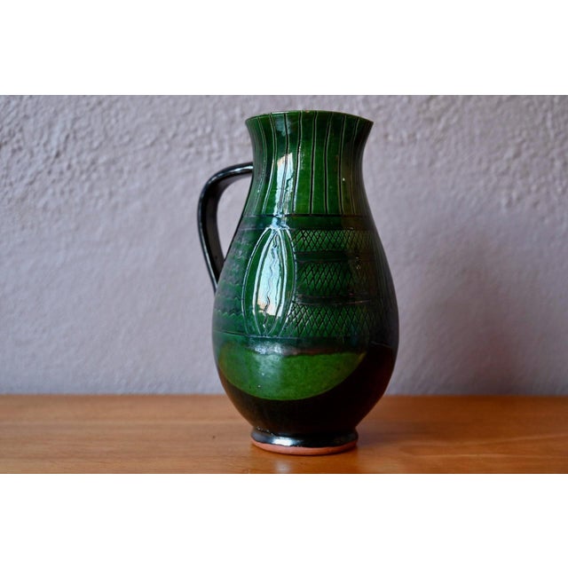 with its rustic yet refined charm, this bohemian glazed terracotta pitcher is quintessentially mid-century. Its slender,...