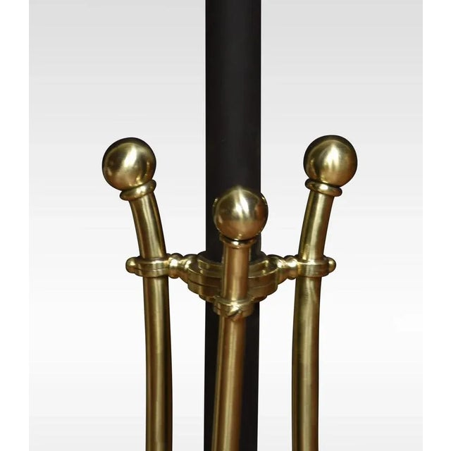 Art Nouveau brass standard lamp, the circular adjustable brass column raised up on outswept sinuous supports, terminating...