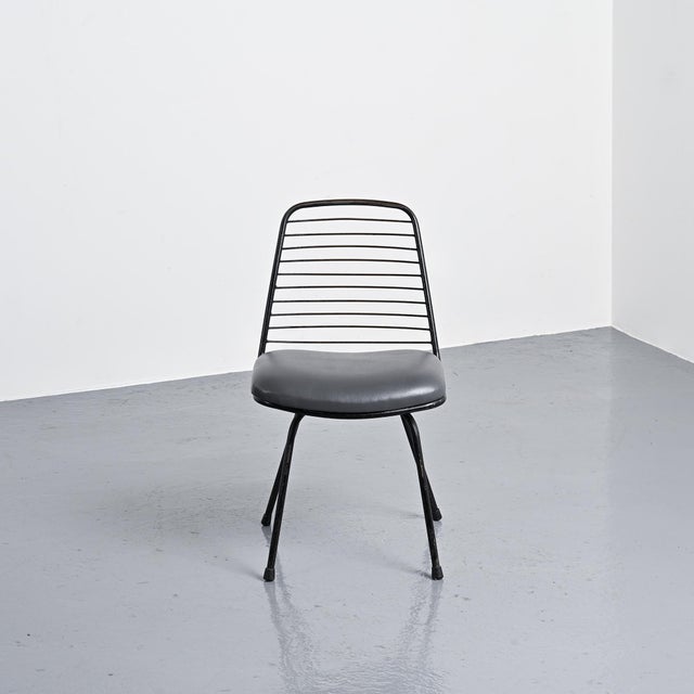 Set of four black lacquered metal chairs with openwork backs by Jean-Louis Bonnant. These chairs are famous for having...