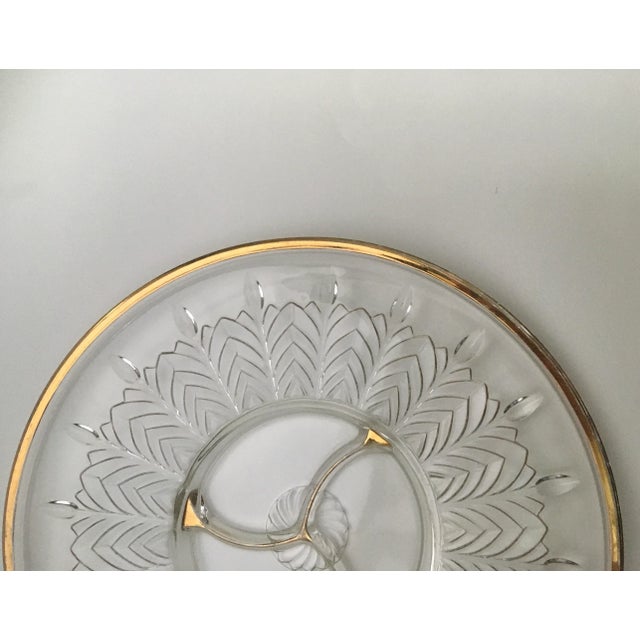 A pressed glass divided party platter featuring a stylized leaf pattern radiating from a tri section center with gold trim...