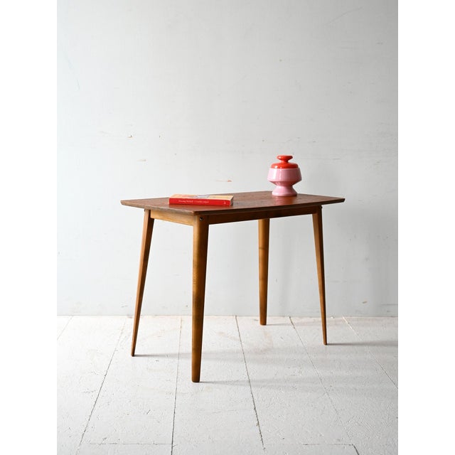 Vintage coffee table with a teak veneer top and tapered solid beech legs. Simple and well-proportioned design....