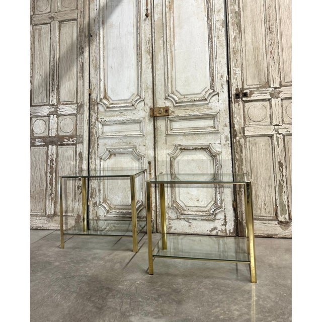 Pair of bronze side tables attributed to Jacques Quinet, circa 1960-70. Double clear glass tops. Rounded uprights....
