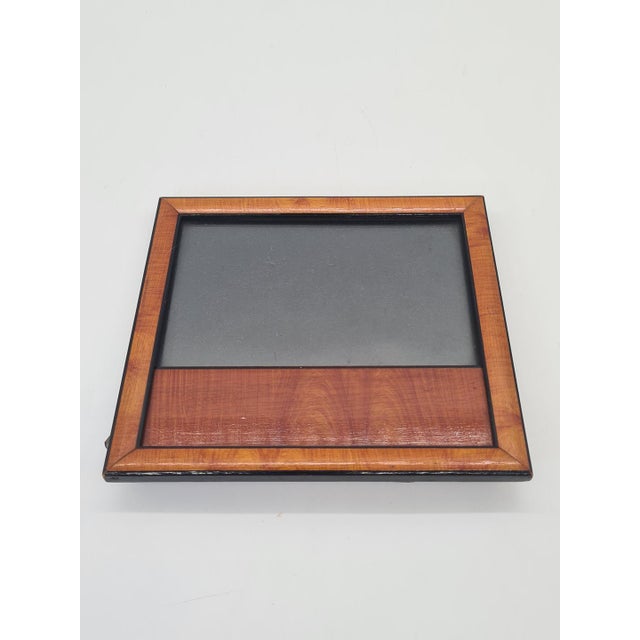 An elegant, small vintage frame made of wood veneered with a decorative veneer featuring a beautiful, natural grain in...