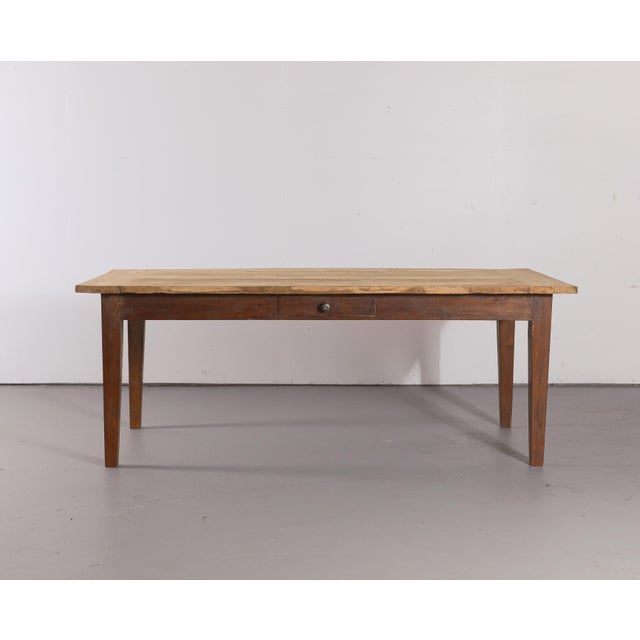A wonderfully characterful antique English farmhouse table featuring a generously sized plank top, simple tapered legs,...