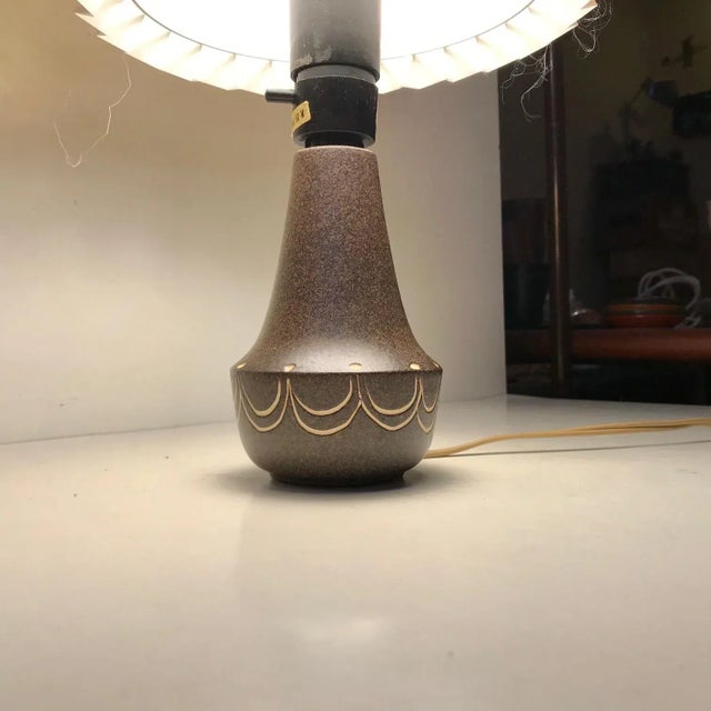 Small ceramic table light decorated in earthy speckled glazes and white/creme waves. It has no signature or markings but...