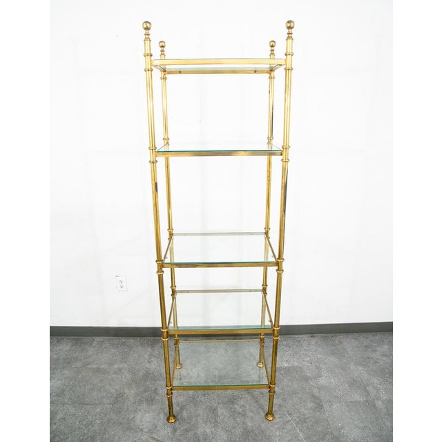 Brass shelving unit with glass shelves throughout. solid and well made. Some patina seen throughout.