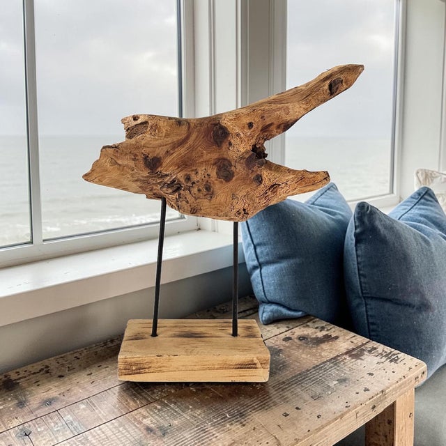 Decorative driftwood sculpture mounted on a custom stand with weathered metal supports and a natural wood base. Created...