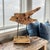 Decorative driftwood sculpture mounted on a custom stand with weathered metal supports and a natural wood base. Created...