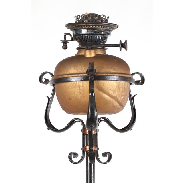 Art Nouveau iron floor lamp with a holder and removable kerosene lamp. The stand utilizes foliate motifs, brass...