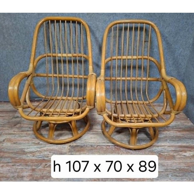 An elegant pair of swivel rattan armchairs, dating from the 1970s, with a design typical of the vintage and bohemian...