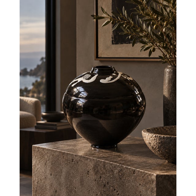 A striking oversized studio pottery vase featuring a sculptural rounded form, deep glossy black glaze, and bold white...
