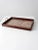A vintage floral tray featuring a wooden frame and a glass-covered floral textile base. Brass handles add a warm metallic...