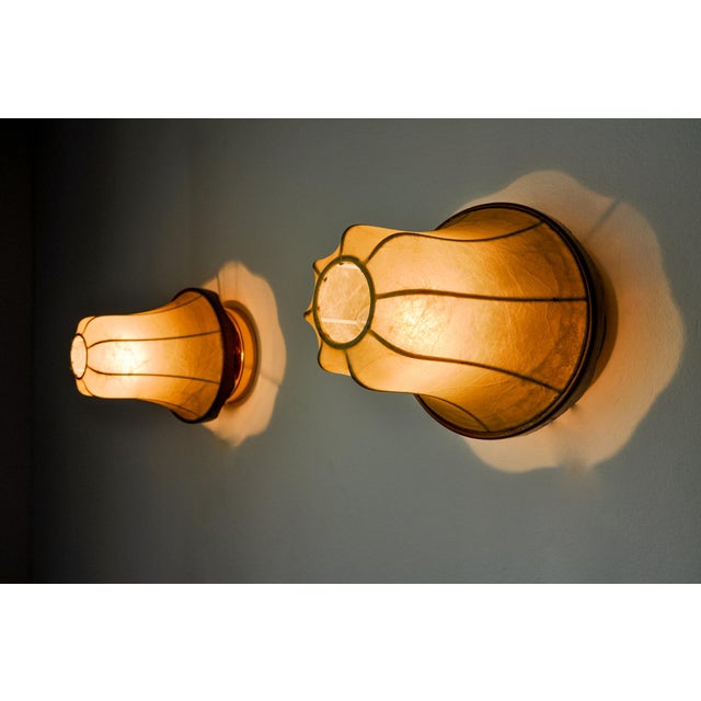 Very beautiful pair of "cocoon" wall lights designed and produced in Italy in the 1970s. Superb manual work of laying...