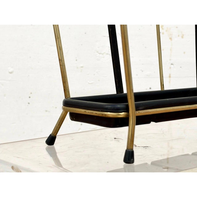 Elegant vintage umbrella stand with a delicate brass-look frame and contrasting black elements. The clean, geometric...