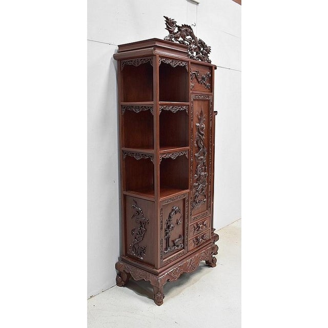 Furniture cabinet of Vietnamese origin in solid mahogany, sumptuously decorated with oriental sculptures. In one piece, it...