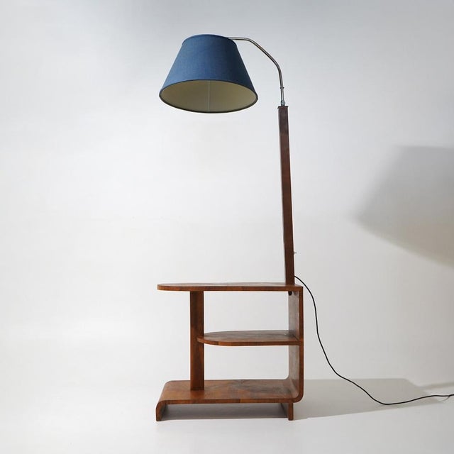 An Italian floor lamp from the 1930s combining lighting, side table, and small shelving unit into a single piece,...