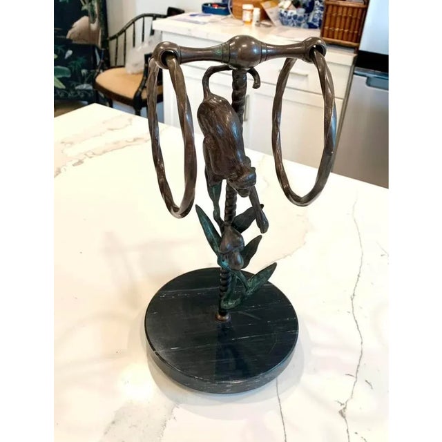 This is a bronze countertop towel holder, made by San Pacific International (SPI), featuring a monkey reaching for fruit....