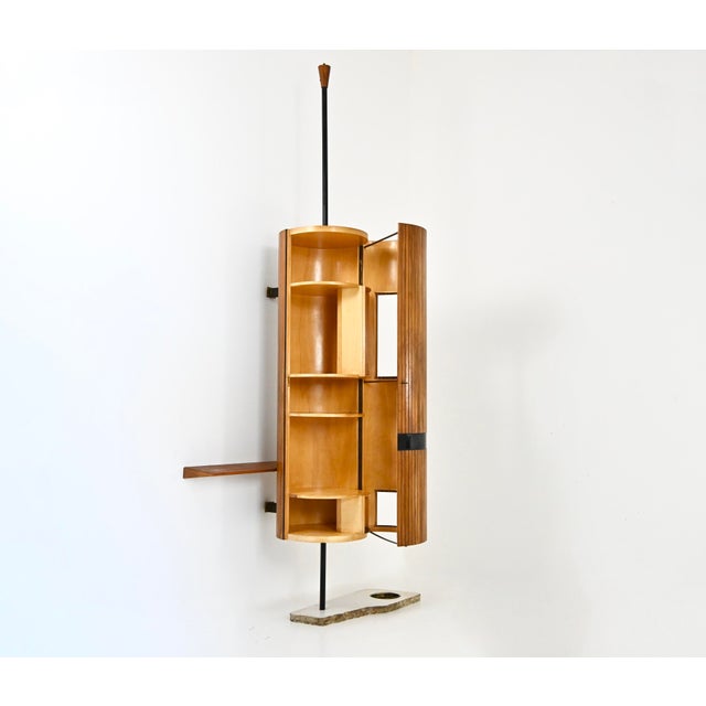 A cylindrical wooden bookcase with a marble base. Shows signs of wear and tear due to age and time. This piece is...