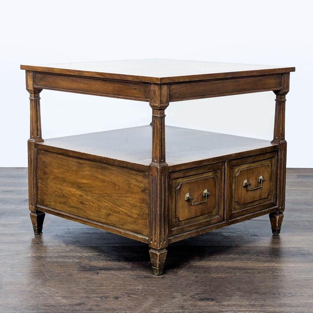 This wooden end table features a classic design with two front doors that open to reveal a spacious storage cabinet. It...