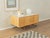 A wonderful sideboard from the 1960s. A high-quality cherry veneer body with two doors and new stainless steel feet in a...