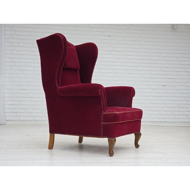 1960s, Danish highback wingback armchair. Original cherry-red furniture velour, ash wood legs, springs in the seat....
