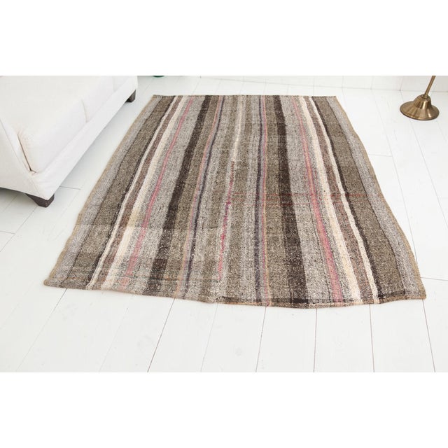 This is a vintage Turkish Oushak rug from the Mid 20th Century. The piece was hand-knotted.