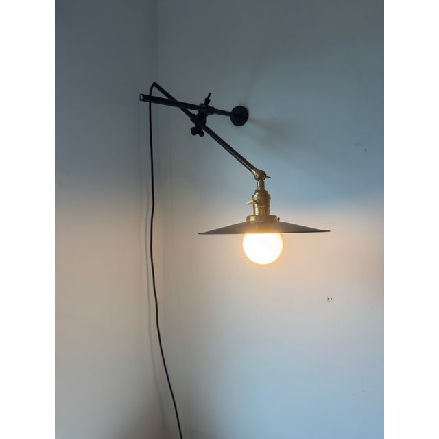 Black/brass. Plug-in. Very good preowned condition. Fixed Arm Depth 18” | Adjustable Arm Length 25” | Shade Diameter 10” |...