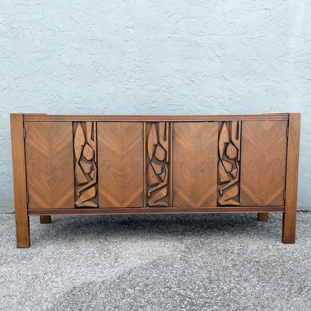 This mid century Brutalist credenza by United Furniture Corporation balances sculptural artistry with refined...