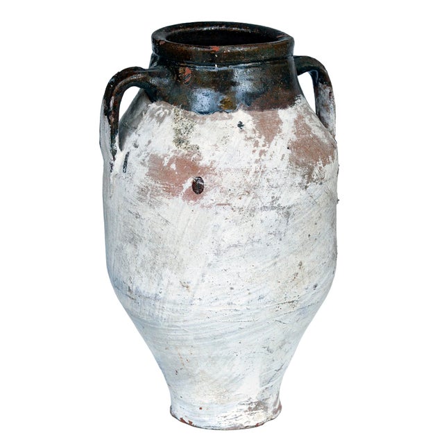 A Vintage Mediterranean Terracotta Olive Oil Jar with two handles. The glazes mouth is a brown color with much of the Jar...