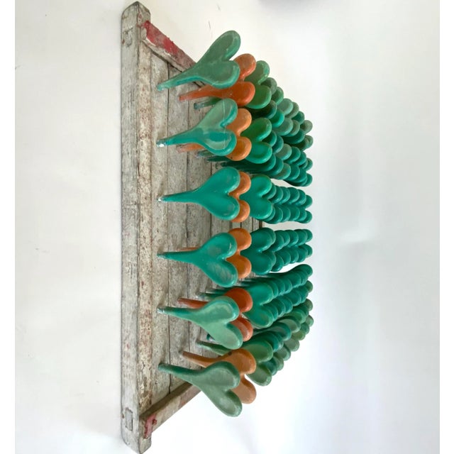A unique piece of industrial salvage with green and orange heart shaped spindles, this sculptural vintage balloon mold...