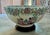 Vintage Chinese Famille Rose porcelain punch bowl featuring hand-painted floral borders and a central court/interior...
