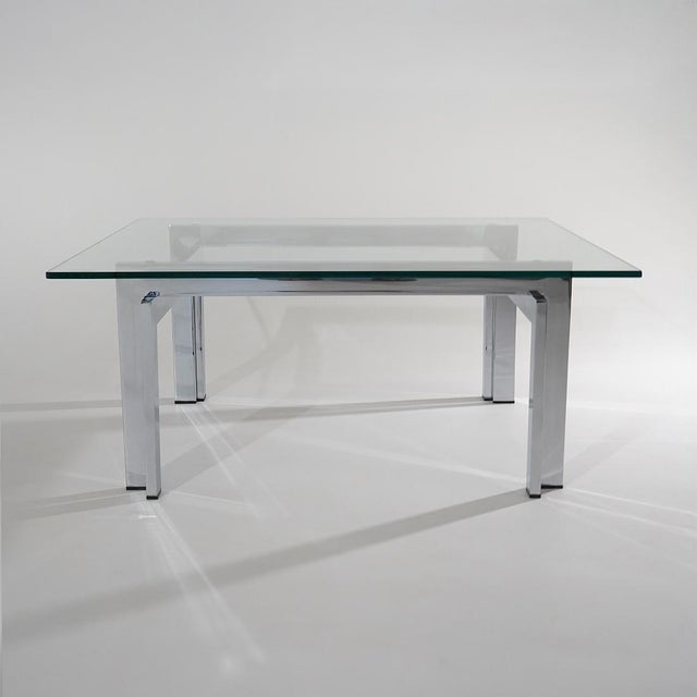 A square coffee table from the 1970s built around the combination of transparent glass and the reflective surface of...