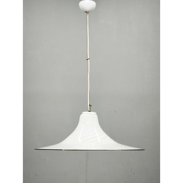 Sculptural Italian pendant light from the 1970s, featuring a large Murano glass shade distinguished by its dramatic flared...