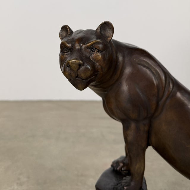 Beautifully hand cast bronze sculpture of a big cat mountain lion (puma), poised on a rock formation. The figure is...