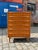 This teak chest of drawers from the 1960s impresses with its elegantly curved handles. The high-quality teak gives the...