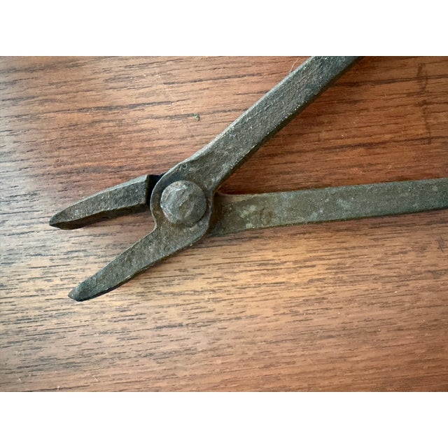 A curated collection of two authentic hand-forged iron workshop tools dating to the late 19th or early 20th century. This...