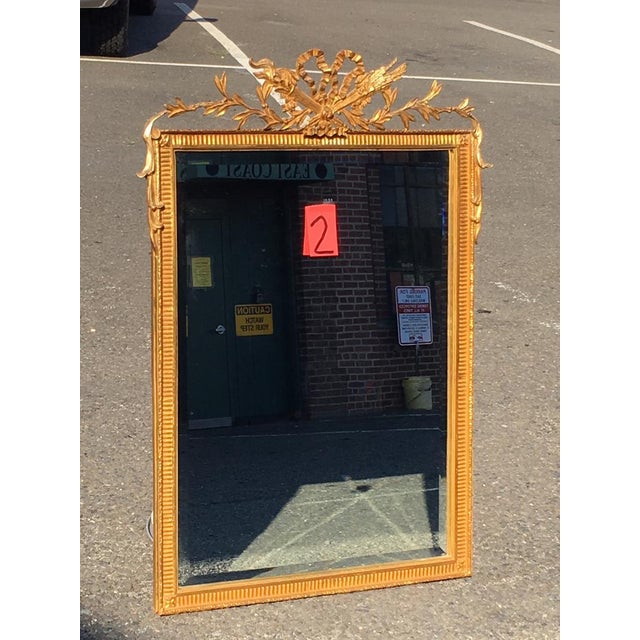 A vintage Carver's Guild French Hunt wall mirror with a beveled glass, beautifully carved gilt fluted frame with corner...
