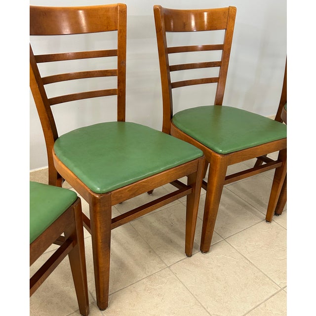 Four solid wood ladder back restaurant/diner chairs circa 1950s. Bent wood frames and intact avocado vinyl seats. Made by...