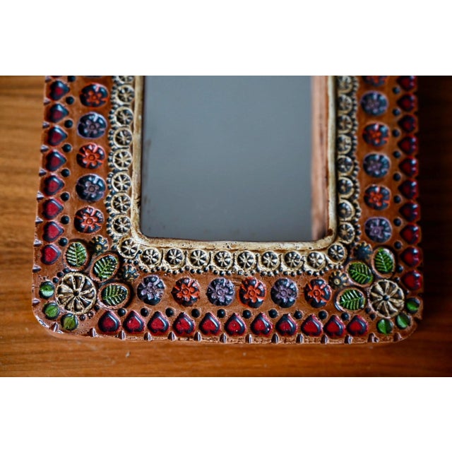 This small, handcrafted ceramic wall mirror evokes the creative and colorful spirit of French pottery workshops in the...