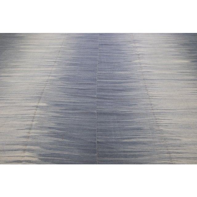 Beautiful modern Kilim flat-weave wool rug in a gray color field with accents of beige in a gorgeous Abstract design. This...