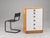 The apartment image and plain background are AI-generated from real photos; the furniture and chair are cut out. The chair...