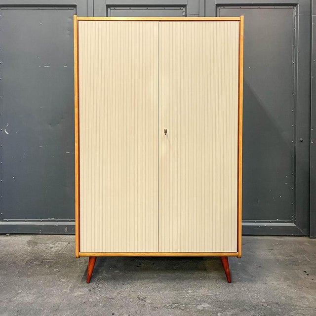 Product: wardrobe style: mid-century · 1960s material: birch veneered frame · solid wood legs · plastic coating on doors...