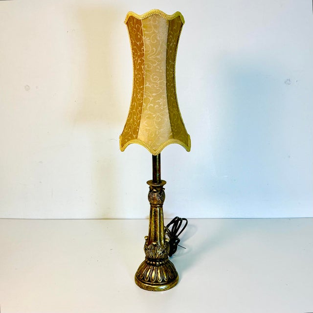 This is a tabletop Nightlight Lamp. It’s in the candlestick style with Neoclassical designs. The base is old-gold with two...