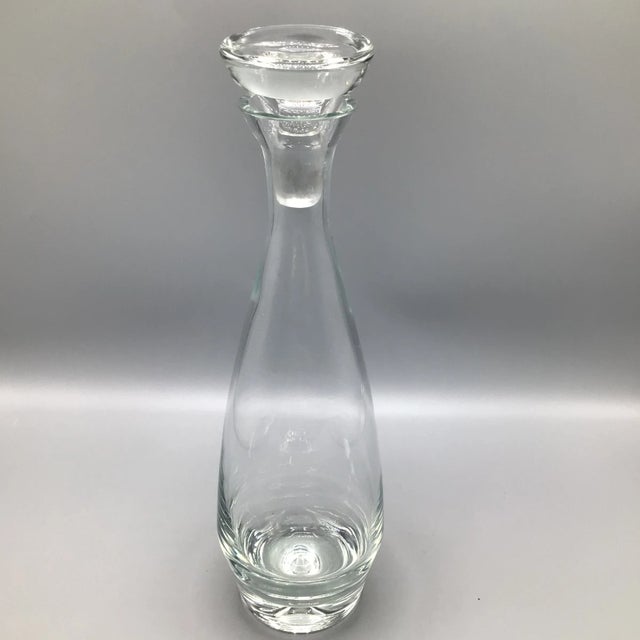 Sleek trim design in this hand blown crystal decanter with heavy bubble bottom base and flat top stopper.