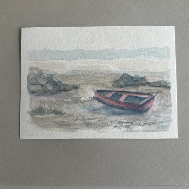 Bring a touch of serenity to your space with this beautifully crafted watercolor painting featuring a solitary rowboat...