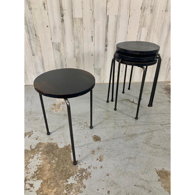 Set of four iron tripod legged stools / tables with ebonized wood tops. There is a nice patina of rust on the legs and...